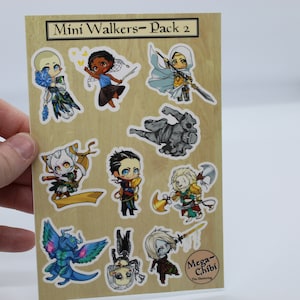 May include: A sheet of stickers featuring 9 different characters in a chibi style. The characters are all in various poses and have different expressions. The stickers are on a wood-grain background and have a white border. The text "Mini Walkers - Pack 2" is at the top of the sheet. The text "Mega-Chibi" is at the bottom of the sheet.