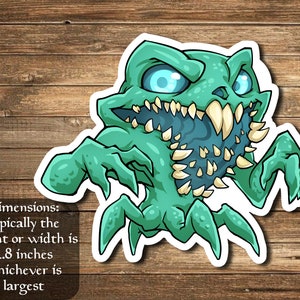 May include: A green monster with sharp teeth and glowing blue eyes. The monster has three claws on each hand and is standing on a wooden surface. Dimensions: typically the height or width is 2.8 inches whichever is largest.