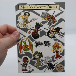 Puede incluir: Una hoja de pegatinas con una variedad de personajes en estilo chibi. Los personajes están dibujados en un estilo de dibujos animados colorido y incluyen un dragón, un caballero, un mago y un guerrero. Las pegatinas están etiquetadas como "Mini Walkers - Pack 1" y "Mega-Chibi".