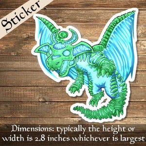Puede incluir: Una pegatina de un dragón verde y azul con una luna creciente en la cabeza. El dragón está en un estilo de dibujos animados y tiene una expresión feroz. La pegatina mide aproximadamente 2,8 pulgadas de ancho.