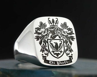 May include: A silver signet ring with a black engraved coat of arms featuring a bird and the text "Di Pofi".