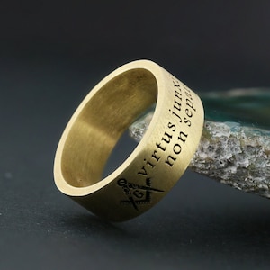 Peut inclure: Une bague en or gravée de l'inscription "Virtus Junxit Non Separabit" et d'un symbole maçonnique.