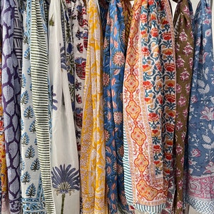 May include: A collection of colorful scarves with floral and geometric patterns. The scarves are made of cotton and are perfect for adding a touch of style to any outfit.