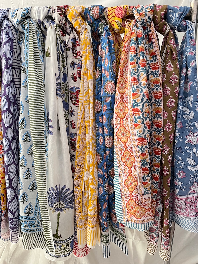 May include: A collection of colorful scarves with floral and geometric patterns. The scarves are made of cotton and are perfect for adding a touch of style to any outfit.