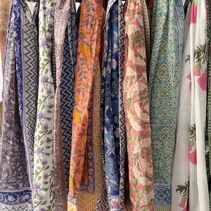 May include: A collection of seven colorful scarves with various floral and geometric patterns. The scarves are made of cotton and are perfect for adding a touch of color and style to any outfit.