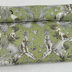 May include: Green kantha quilt with a white and brown pattern of animals, birds, and plants. The quilt is made of cotton and has a hand-stitched design.