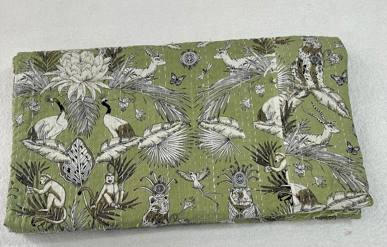 May include: A green kantha quilt with a white and brown floral and animal print. The print features monkeys, birds, tigers, and deer.