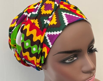 Puede incluir: Un turbante colorido con un patrón geométrico en tonos de rojo, amarillo, verde, morado y blanco.