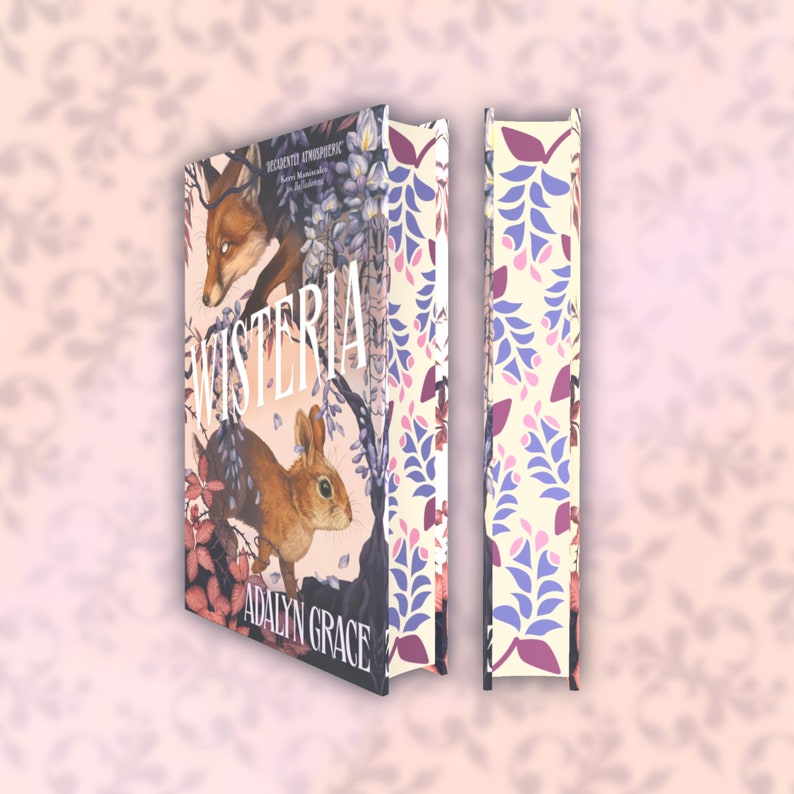 May include: A hardcover book titled "Wisteria" by Adalyn Grace, featuring a fox and a rabbit illustration. The spine displays a floral pattern in purple, pink, and cream. The cover art has a whimsical, illustrated style.