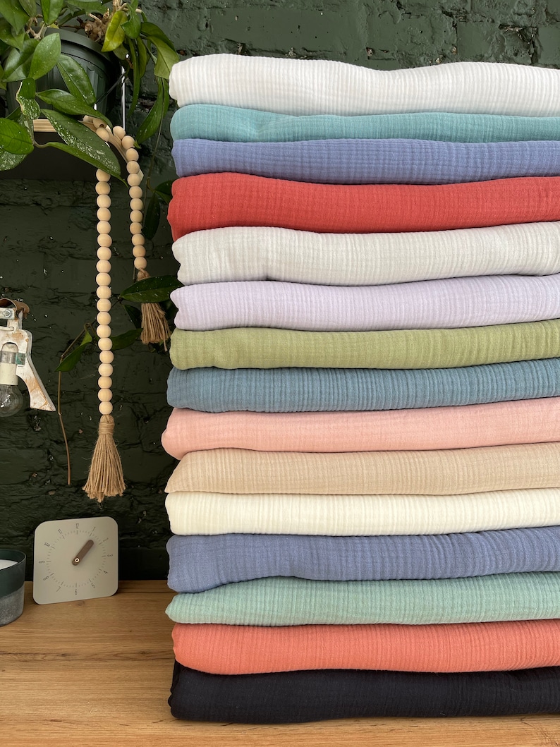 Pu&ograve; includere: Un mucchio di 14 campioni di tessuto di diversi colori. I campioni sono tutti realizzati con un materiale morbido e testurizzato. I colori includono bianco, azzurro, blu, rosso, lavanda, verde, rosa, beige, blu scuro, blu verde, corallo e nero.
