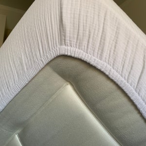 May include: White fitted sheet with a textured, waffle-like pattern. The sheet is made of a soft, breathable fabric.