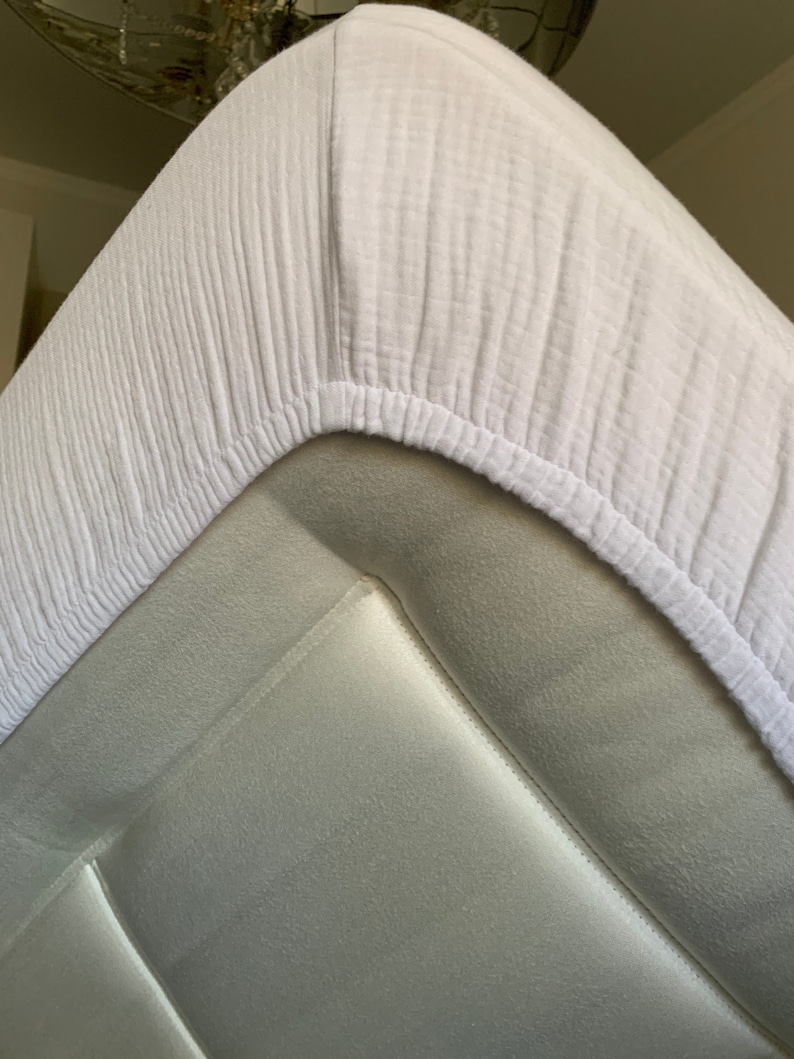 May include: White fitted sheet with a textured, waffle-like pattern. The sheet is made of a soft, breathable fabric.