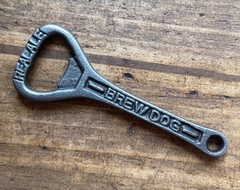 May include: A black metal bottle opener with the words "Brew Dog" and "Real Ale" embossed on it.