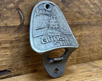 May include: A silver metal bottle opener with a ship design and the text "Adnams Ghost Ship".