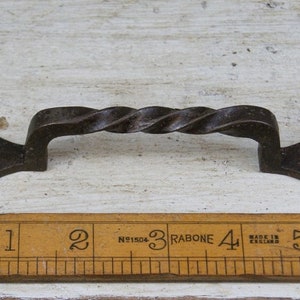 May include: A twisted metal door handle with a decorative, pointed end. The handle is approximately 4 inches long.