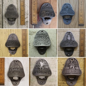 May include: Ten different cast iron bottle openers with various brewery logos and names. The bottle openers are all in the shape of a shield or crest. The logos include "Freler's London Pride", "The One and Only New Castle Brownale", "Marston's Beer Company", "Shepherd Neame", "Ingrateful Memory of the Few Premium Spitfire Kentish Ale", "Theakston 1827", "Edinburgh Castle", "Est. 1865 Real Ale Camerons", and "Est. 1882 Brains".
