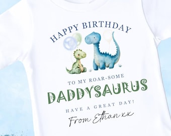 May include: White t-shirt with a dinosaur graphic and the text "HAPPY BIRTHDAY TO MY ROAR-SOME DADDYSAURUS". The design features two dinosaurs, balloons, and the name "Ethan". A perfect gift for a dad.