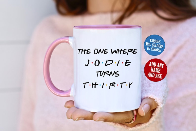 May include: White ceramic mug with a pink interior and handle. The mug features the text "THE ONE WHERE JODIE TURNS THIRTY" in black, with the word "THIRTY" in the style of the TV show Friends. Additional text on the mug says "VARIOUS MUG COLOURS TO CHOOSE" and "ADD ANY NAME AND AGE".