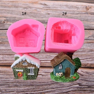 Puede incluir: Dos moldes de silicona para hacer casas en miniatura. El primer molde es rosa y tiene una forma de casa simple. El segundo molde es rosa y tiene una forma de casa m&aacute;s detallada con una chimenea y ventanas. Hay dos casas en miniatura terminadas, una con un techo nevado y la otra con un techo marr&oacute;n.