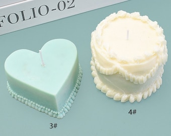 Puede incluir: Dos velas decorativas. Una tiene forma de corazón, verde claro, y tiene una base con cuentas. La otra tiene forma de pastel, blanquecina, con un diseño con volantes. Ambas velas tienen una sola mecha. Los números 3# y 4# están impresos en las velas.