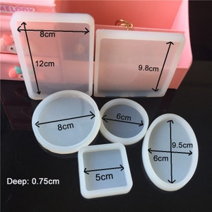May include: Six clear silicone moulds for resin crafts. The moulds are in various shapes, including a square, rectangle, circle, and oval. The moulds are labelled with measurements in centimetres. Deep: 0.75cm.