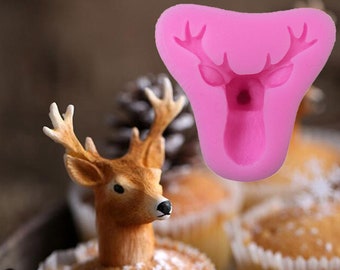 May include: Pink silicone mold shaped like a deer head with antlers. The mold is used for making cake decorations.