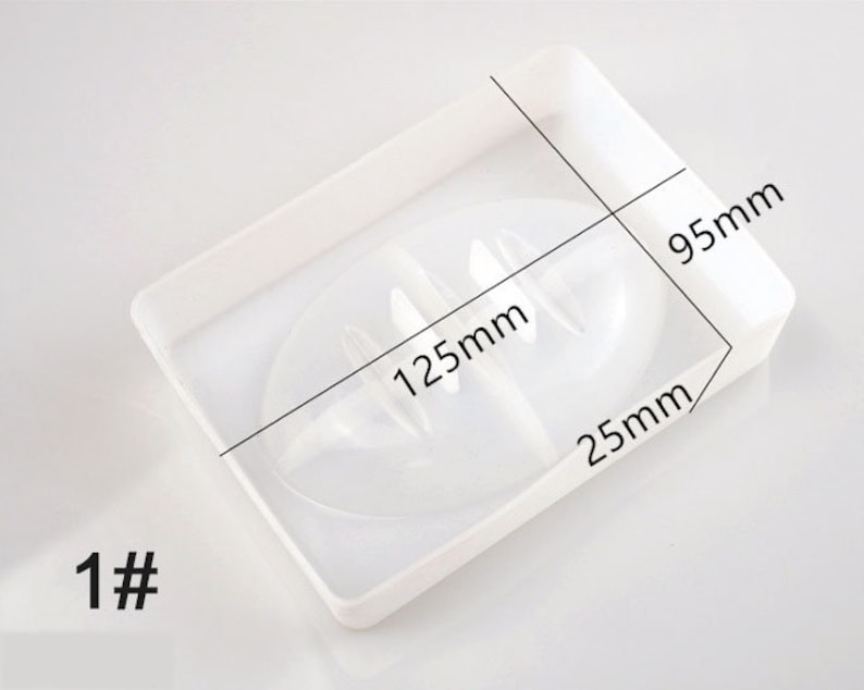 May include: White plastic soap dish with two compartments. The dish measures 12.5cm by 9.5cm by 2.5cm.