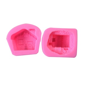 Puede incluir: Dos moldes de silicona rosa para hacer golosinas con forma de casa de jengibre. Un molde muestra la parte delantera de la casa y el otro muestra la parte trasera.