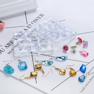 Pode incluir: Molde de pl&aacute;stico transparente com 10 formas diferentes para fazer brincos de resina. O molde &eacute; mostrado com brincos de resina acabados em v&aacute;rias formas e cores.