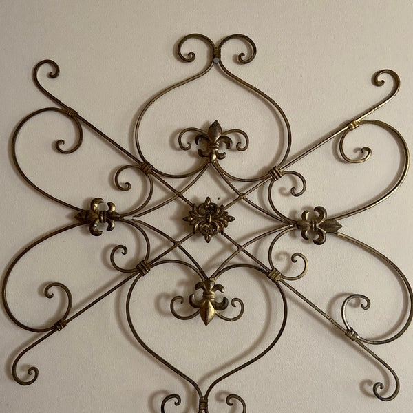 Fleur de lis Old metal gold colored boho wallhanging with fleur de lis designs.Fairly heavy.Would make a nice trellis for ivy(not included)