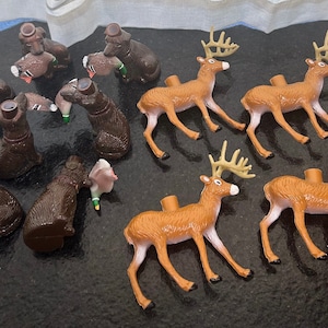 May include: A collection of brown and tan plastic deer and duck figurines. The deer figurines have antlers and are standing on all four legs. The duck figurines are in a variety of poses, some with their wings spread and some with their heads tucked in.