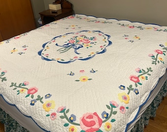 Lovely Arch quilt of Hawthorne New York quilt with beautiful floral appliqués and scalloped edges. Displaying in photos on a king sized bed.