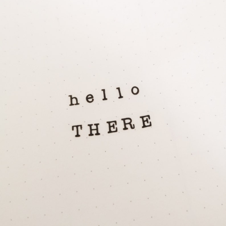 May include: A white sheet of paper with black text that reads "hello there" in a typewriter font.