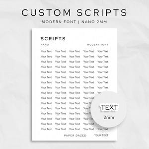 以下が含まれることがあります： 上部に「CUSTOM SCRIPTS」と「MODERN FONT | NANO 2MM」という文字が入った白いシート。シートには、モダンなフォントで「Your Text」という単語が並んでいます。丸いステッカーには「TEXT 2mm」と書かれています。