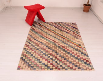 May include: A vintage rug with a checkered pattern in shades of blue, red, yellow, and green. The rug has a cream background and is made of wool.