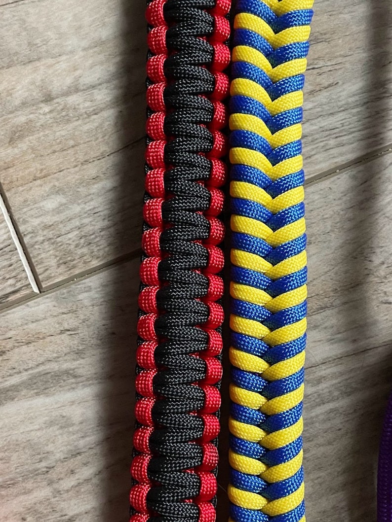 Puede incluir: Dos pulseras de paracord, una negra y roja, la otra azul y amarilla. Las pulseras est&aacute;n tejidas con un punto cobra.