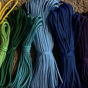 Puede incluir: Una colecci&oacute;n de 15 carretes de paracord de colores, cada uno enrollado apretadamente y dispuestos en un patr&oacute;n de arco&iacute;ris. El paracord es un tipo de cuerda de nylon utilizada para manualidades, supervivencia y actividades al aire libre.