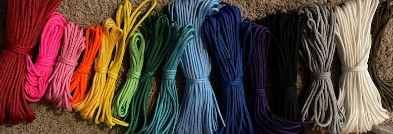 Puede incluir: Una colecci&oacute;n de 15 carretes de paracord de colores, cada uno enrollado apretadamente y dispuestos en un patr&oacute;n de arco&iacute;ris. El paracord es un tipo de cuerda de nylon utilizada para manualidades, supervivencia y actividades al aire libre.