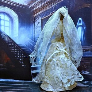 May include: A white lace wedding dress with a long veil, the dress is on a mannequin in a room with a staircase and a painting of a ghost.