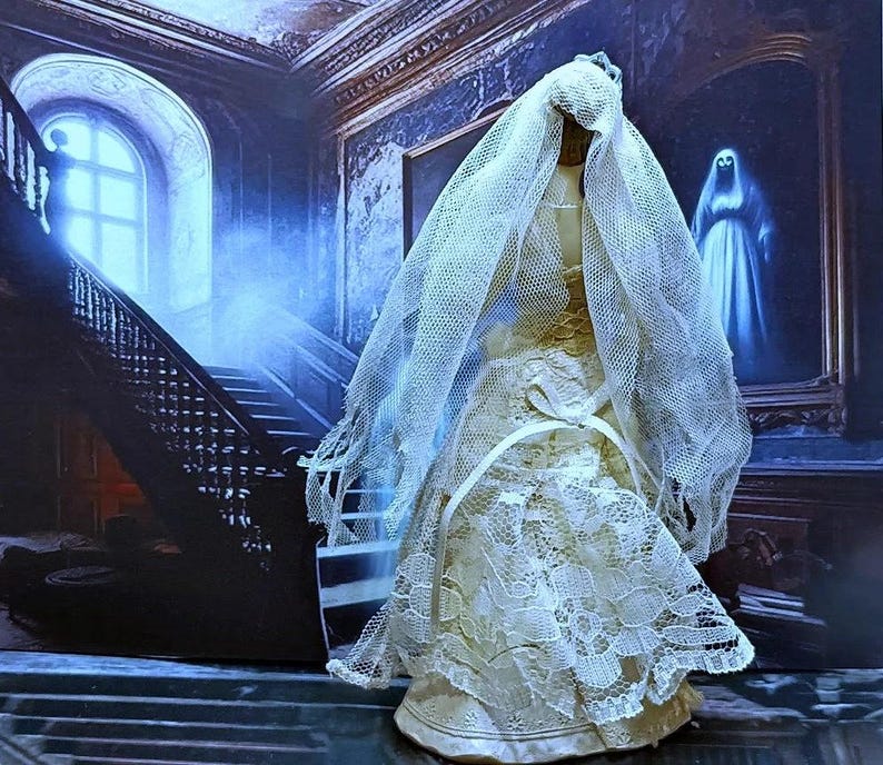 May include: A white lace wedding dress with a long veil, the dress is on a mannequin in a room with a staircase and a painting of a ghost.