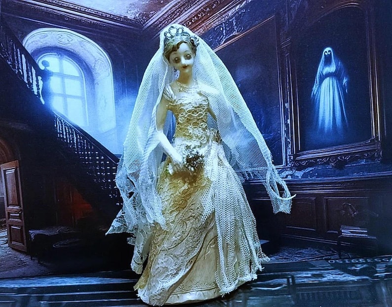 May include: A porcelain doll dressed in a white wedding gown with a lace veil. The doll is standing in a dark, gothic-style room with a staircase and a painting of a ghost in the background.