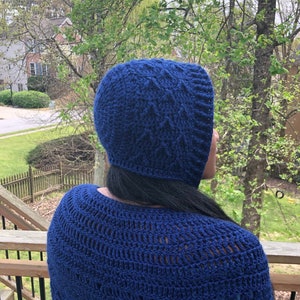 May include: A navy blue crochet hat and matching shawl. The hat has a textured pattern, and the shawl features a detailed openwork design. The items are made of a soft, dark blue yarn, perfect for cooler weather.