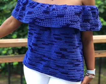 May include: A royal blue crochet top with a ruffled off-the-shoulder neckline. The top has a short sleeve and a loose fit.