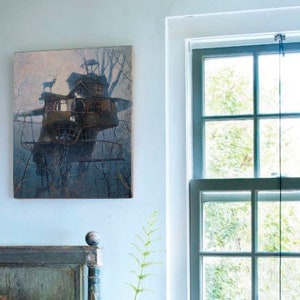 Puede incluir: Un dormitorio con una cama blanca, una cabecera de madera y una mesita de noche de metal negro. Se ve una ventana con vistas a los &aacute;rboles y una silla con un coj&iacute;n rosa. Dos cuadros enmarcados cuelgan de la pared, uno con una casa en el &aacute;rbol y el otro con un jarr&oacute;n.