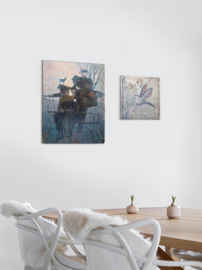 Puede incluir: Dos cuadros enmarcados en una pared blanca. El cuadro m&aacute;s grande es una acuarela de una casa en un &aacute;rbol con un cielo azul claro y dos ciervos. El cuadro m&aacute;s peque&ntilde;o es una acuarela de un p&aacute;jaro con un fondo azul claro.