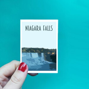 Może przedstawiać: Biała karta z nadrukowanym czarnym tekstem "NIAGARA FALLS". Karta przedstawia stylizowaną ilustrację wodospadu Niagara w niebiesko-zielonej kolorystyce.
