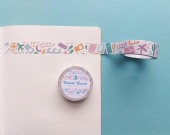 May include: A roll of pastel colored washi tape with travel themed illustrations. The tape is on a white notebook and the roll is labeled "Pastel Travel Washi Tape 15mm".