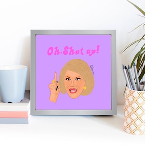 May include: A framed print with a lilac background features an illustration of a woman gesturing with her index finger. The text "Oh, Shut up!" is written above her head in pink. The woman has blonde hair, gold earrings, and a gold ring.
