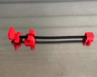 May include: Red plastic cord locks with a black cord threaded through them.