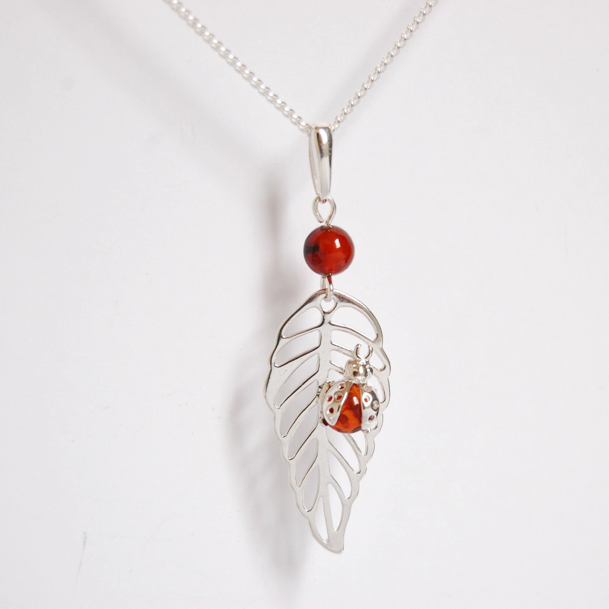 Collier coccinelle en ambre et argent. - France